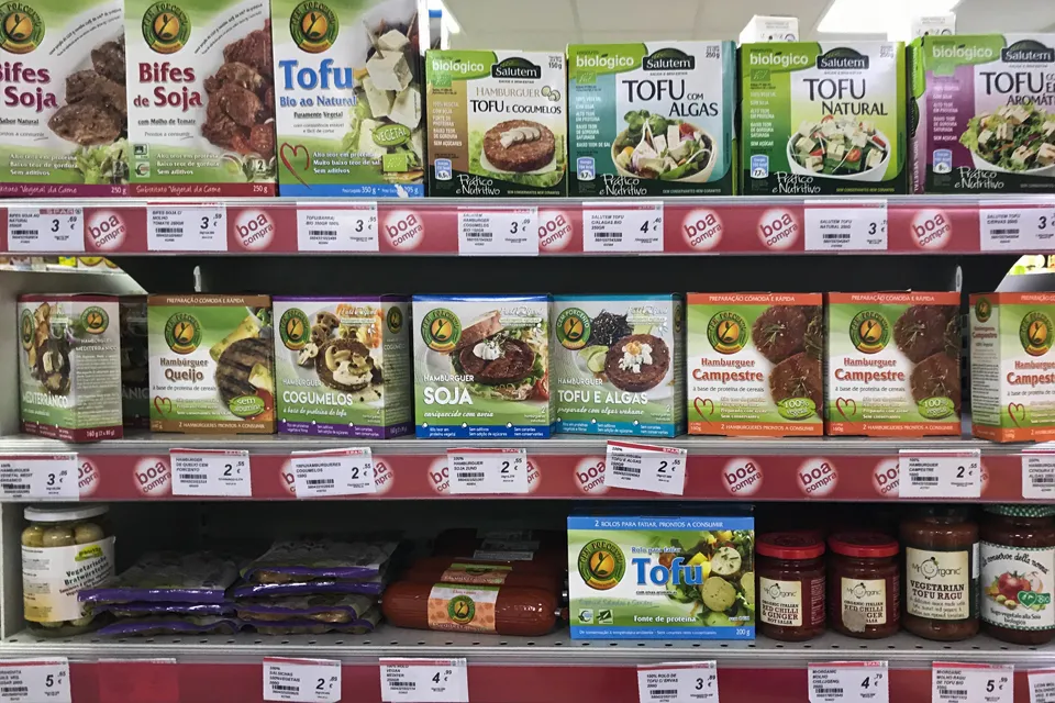 Reichhaltig gefülltes Regal mit veganen Milchalternativen und anderen pflanzlichen Produkten in einem Supermarkt