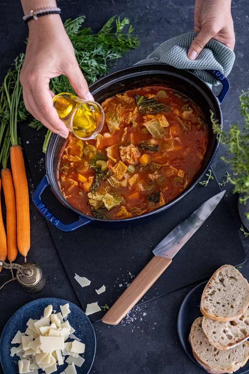 Reichhaltige Ribollita, Garniert mit frischen Kräutern und einem Schuss Olivenöl, bereit zum Genuss