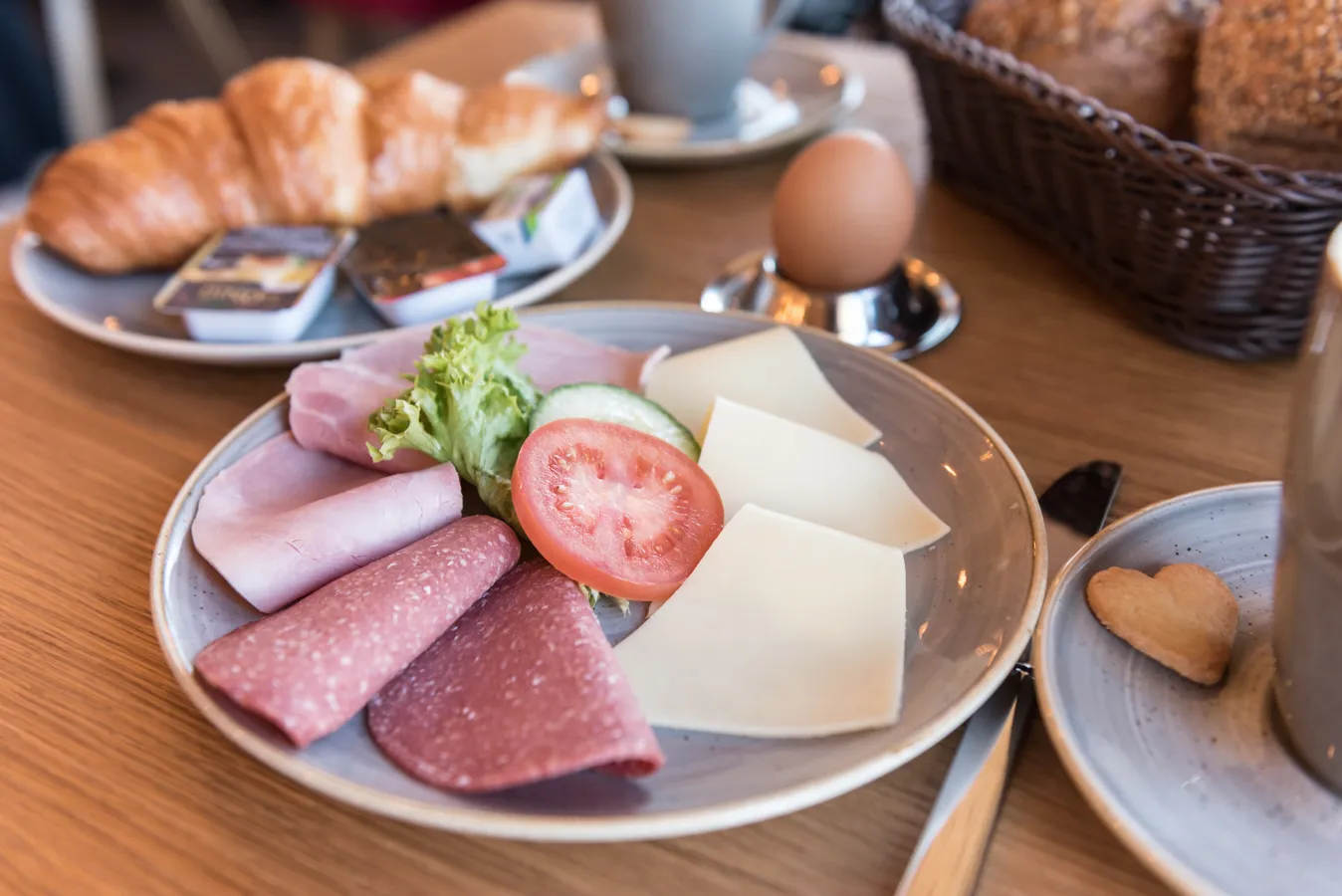 Reichhaltiges Frühstück mit Brötchen, Aufschnitt und Kaffee bei Döbbe