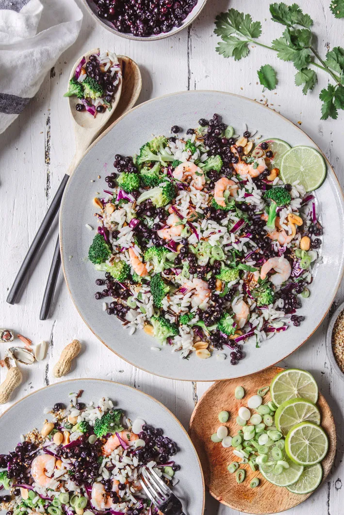 Reissalat mit Blaubeeren auf zwei Tellern und viel Deko auf dem Teller