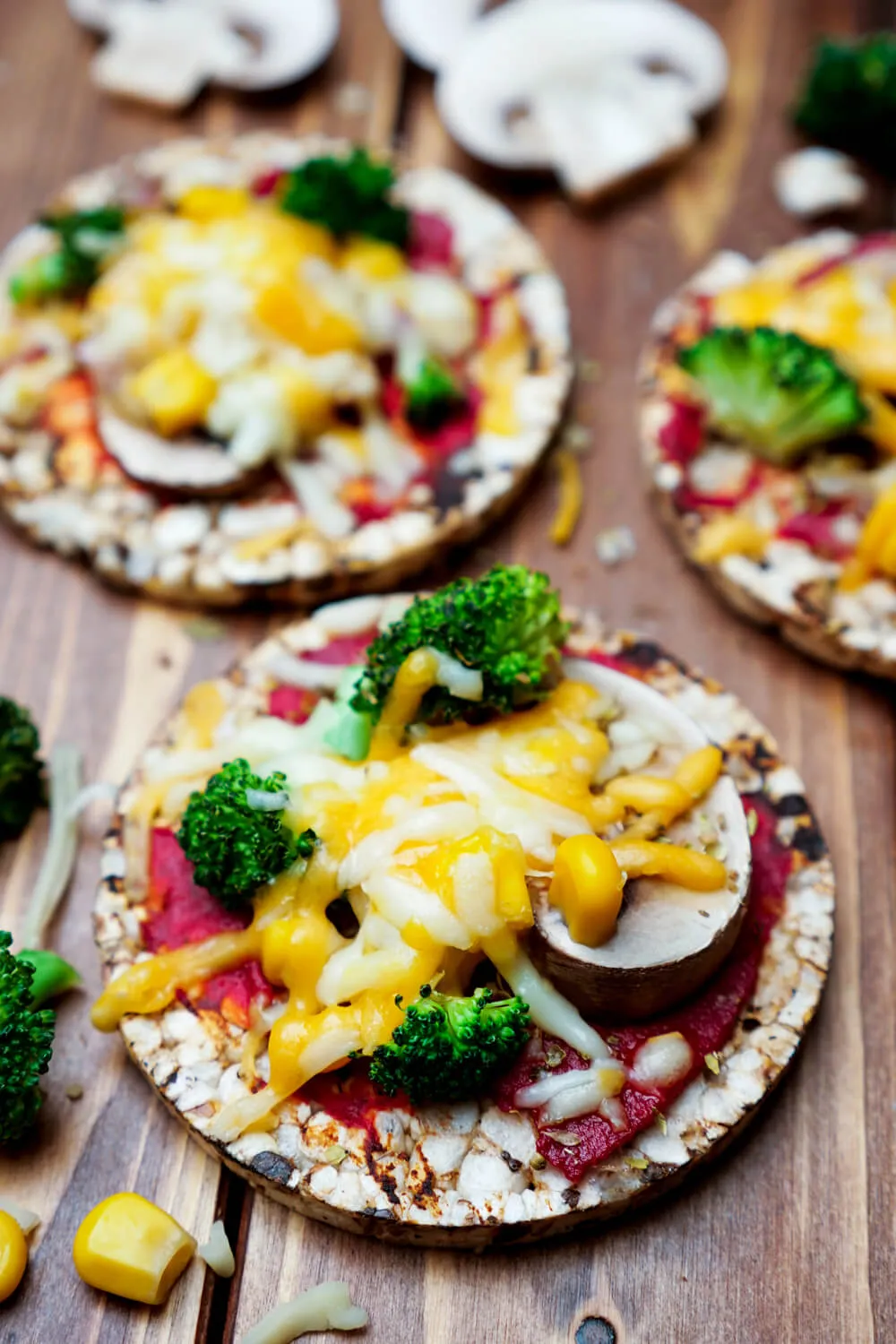 Reiswaffel-Pizza mit Tomatensauce, Champignons, Brokkoli, Mais und Käse belegt