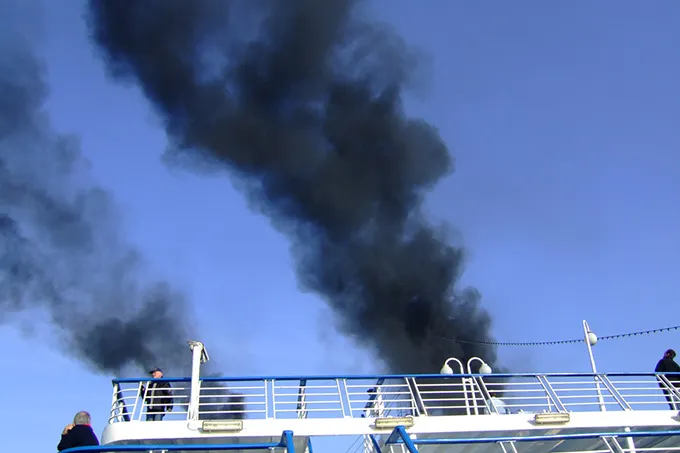 Reling eines Kreuzfahrtschiffes, das schädliche Emissionen ausstößt