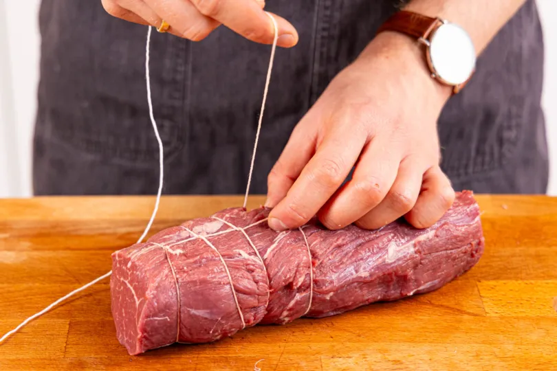 Rinderlende mit Küchengarn binden für gleichmäßiges Garen und Formstabilität