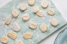 Rohe Gnocchi auf Backpapier, vorbereitet zur Lagerung im Kühlschrank oder zum Einfrieren.