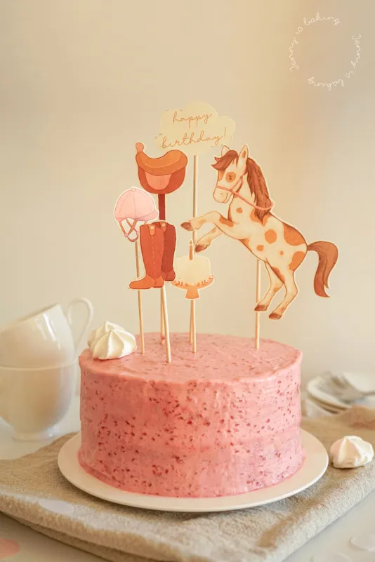 Rosa Sahnetorte mit Himbeeren und eleganten Torten-Toppern für Kindergeburtstage