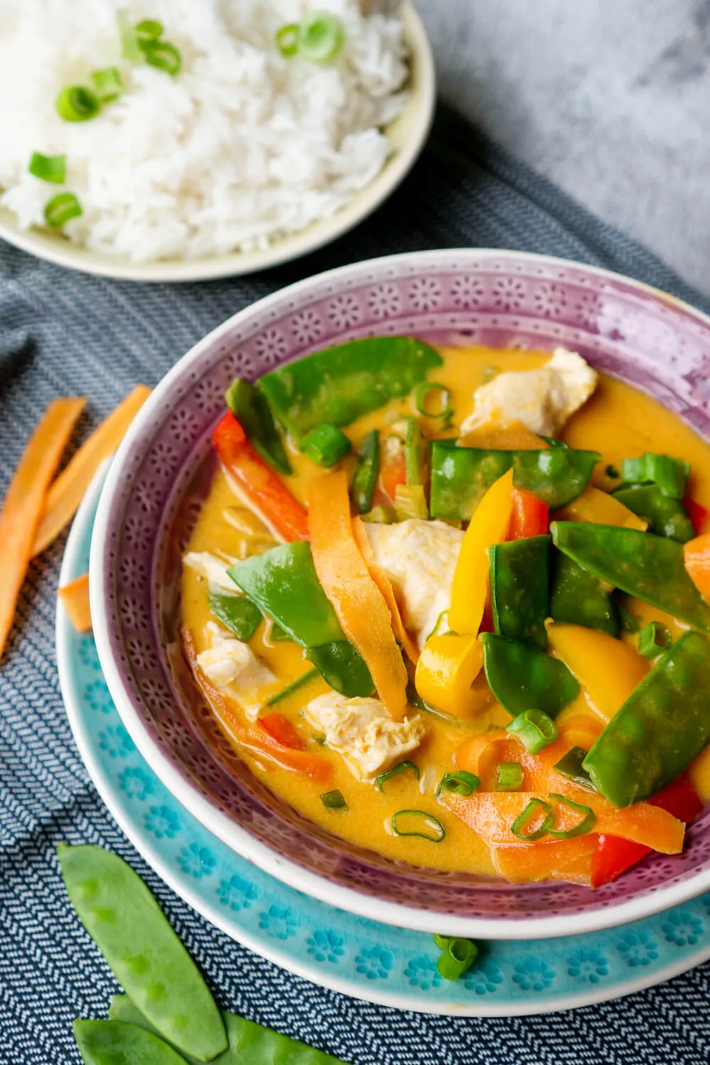 Rotes Curry mit Kaiserschoten, Hähnchen, Möhren und Paprika in der lila Schüssel