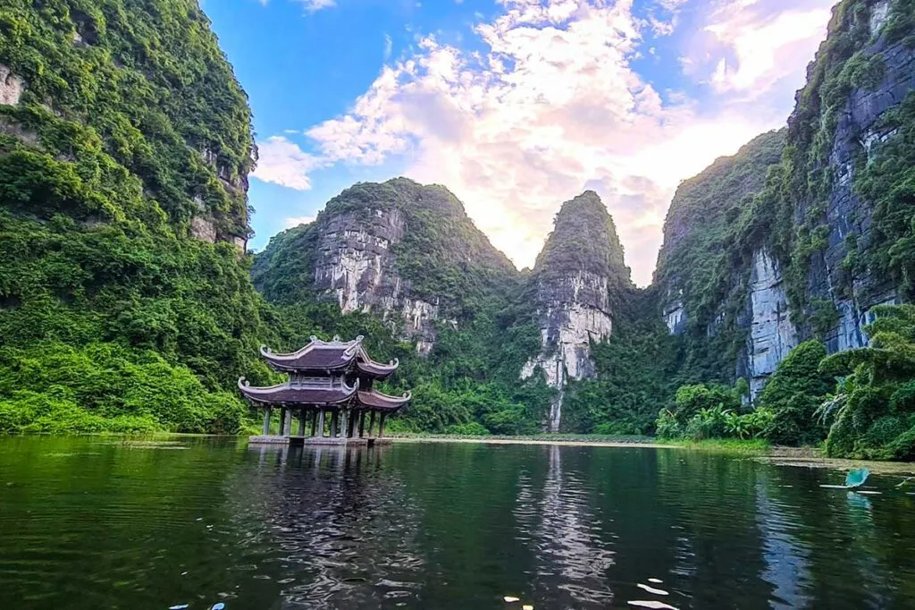 Ruderboot fährt durch die beeindruckende Karstlandschaft von Trang An, ein UNESCO-Welterbe in Nordvietnam