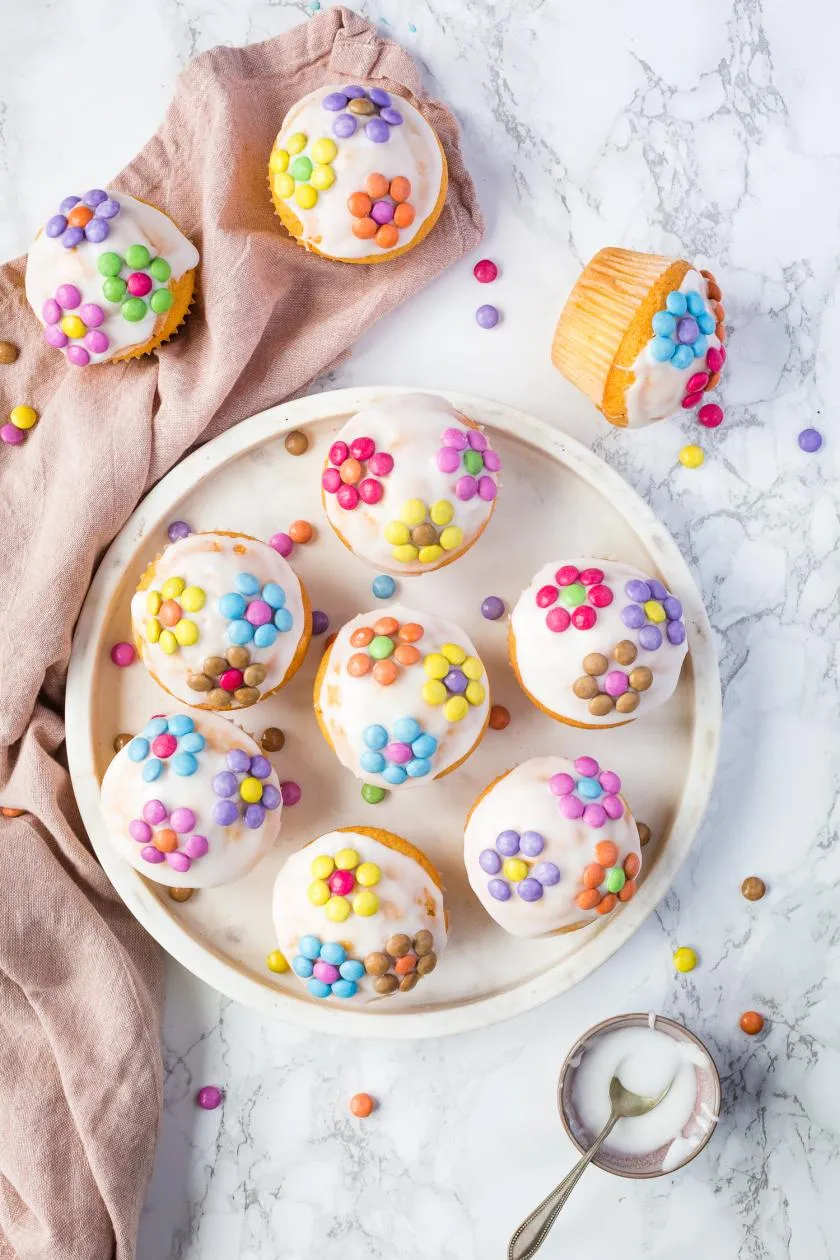 Saftige Fanta-Muffins dekoriert mit farbenfrohen Smarties-Blumen