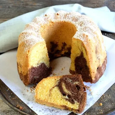 Saftiger glutenfreier Marmorkuchen als Gugelhupf, mit Puderzucker bestäubt und angeschnitten, zeigt die klassische Schoko-Vanille-Marmorierung