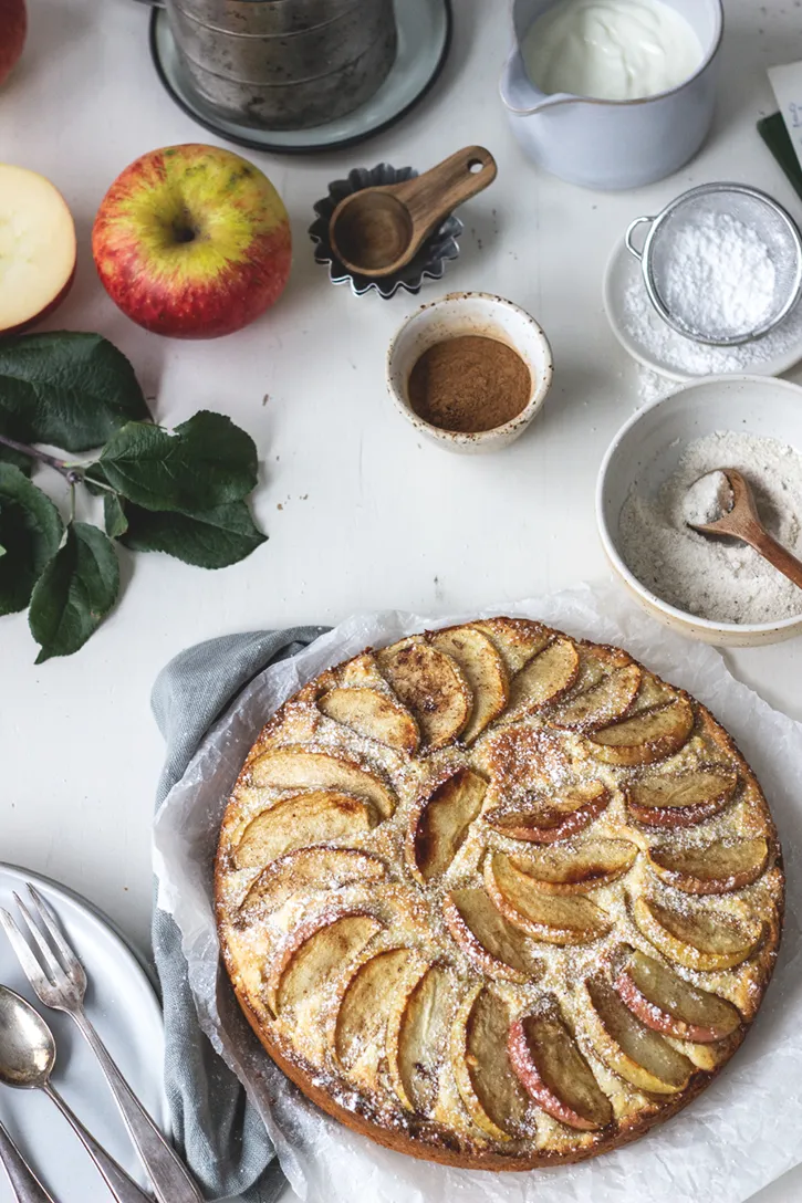 Saftiger schwedischer Apfelkuchen mit Zimt und Äpfeln, gebacken in einer Springform, servierbereit auf einem Holztisch.