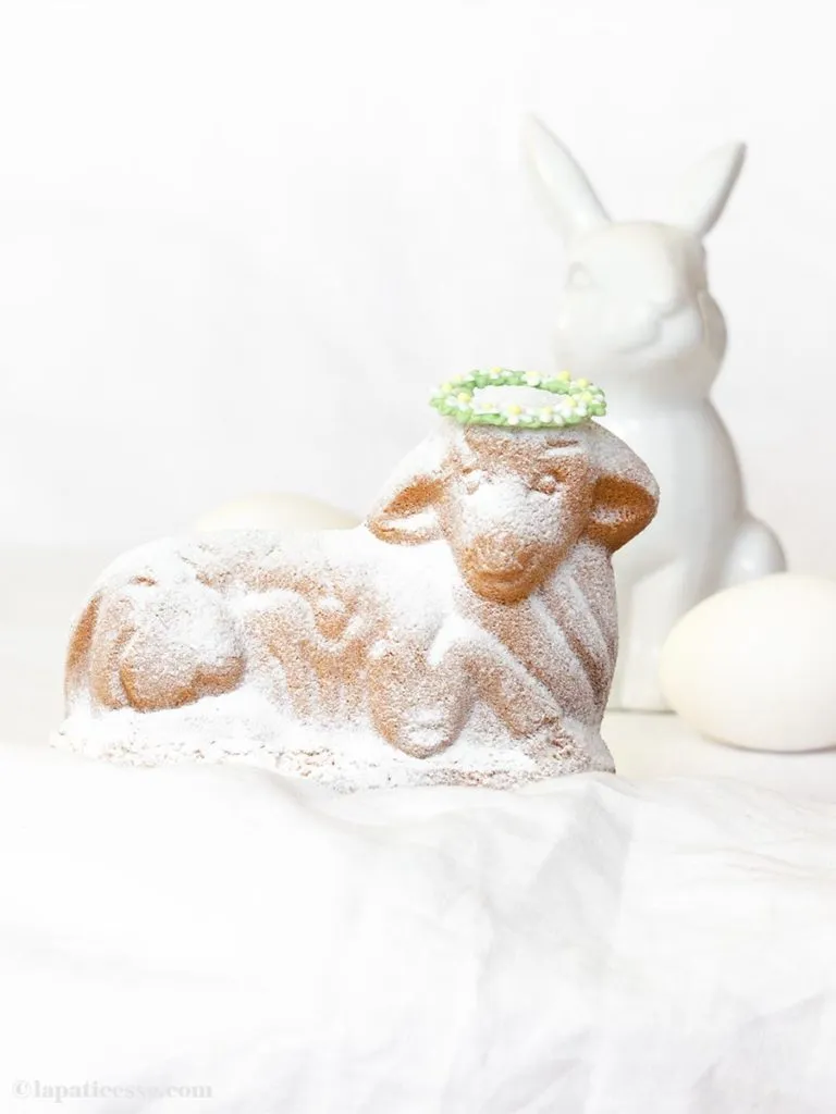 Saftiges Osterlamm mit Mandeln und Orangensaft, bestäubt mit Puderzucker, bereit für die Osterkaffeetafel.