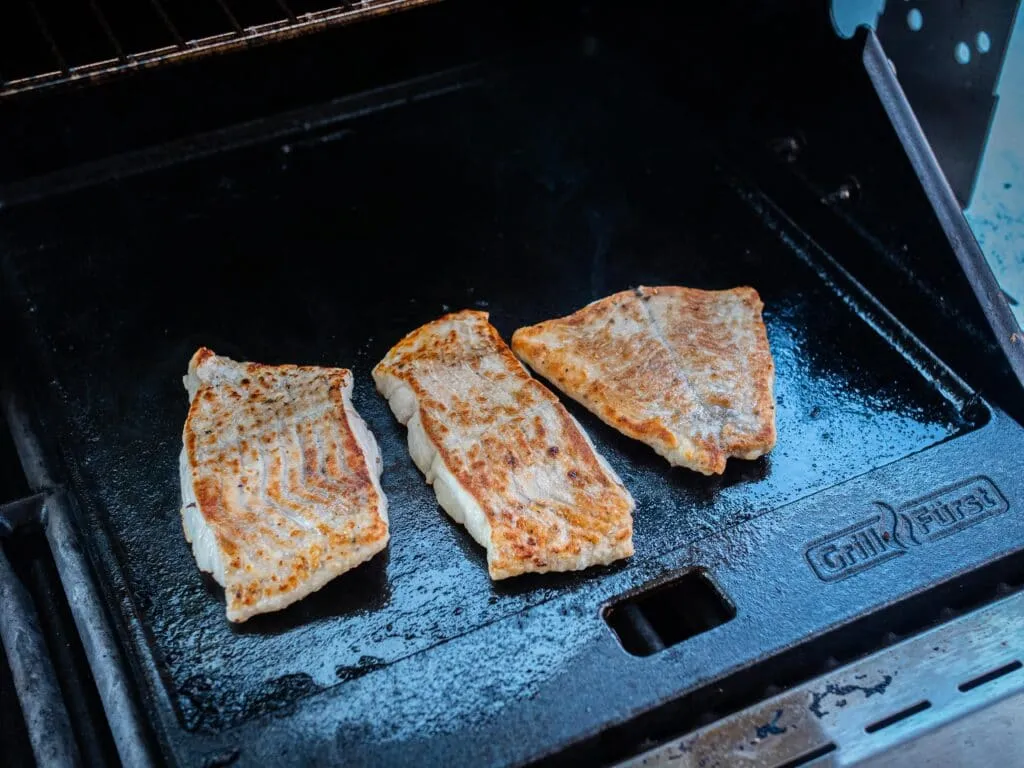 Saftiges Seelachsfilet, perfekt auf einer Gusseisen Grillplatte zubereitet, eine hervorragende Wahl für vielfältige Fisch Grillrezepte