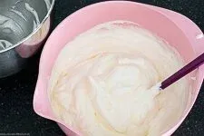 Sahne unter die Schmand-Masse heben für die schnelle Windbeuteltorten-Creme.