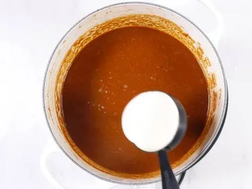 Sahne zum Chicken Tikka Masala hinzufügen