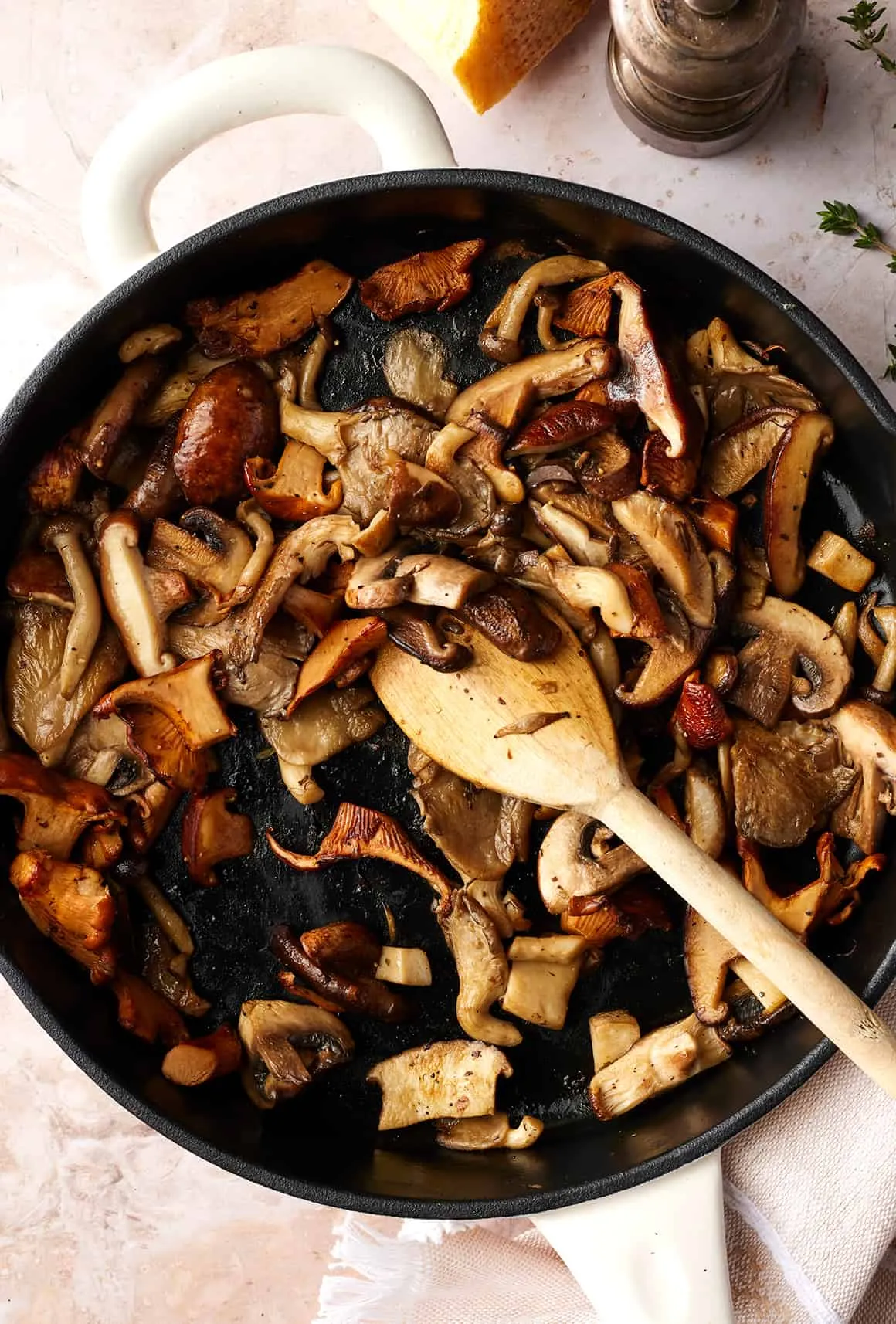Sauteed mushrooms in skillet with wooden spoon