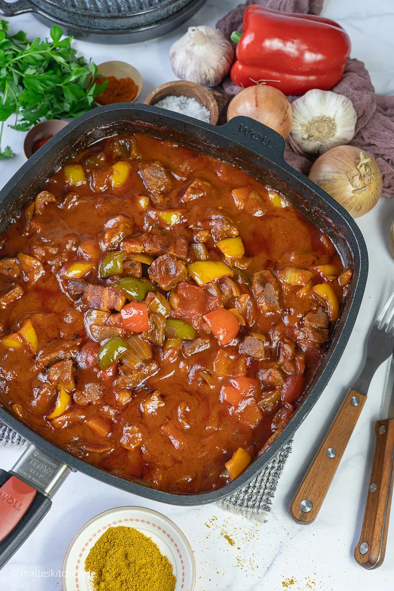 Schaschliktopf mit Speck, Zwiebeln und Paprika, bereit zum Backen.