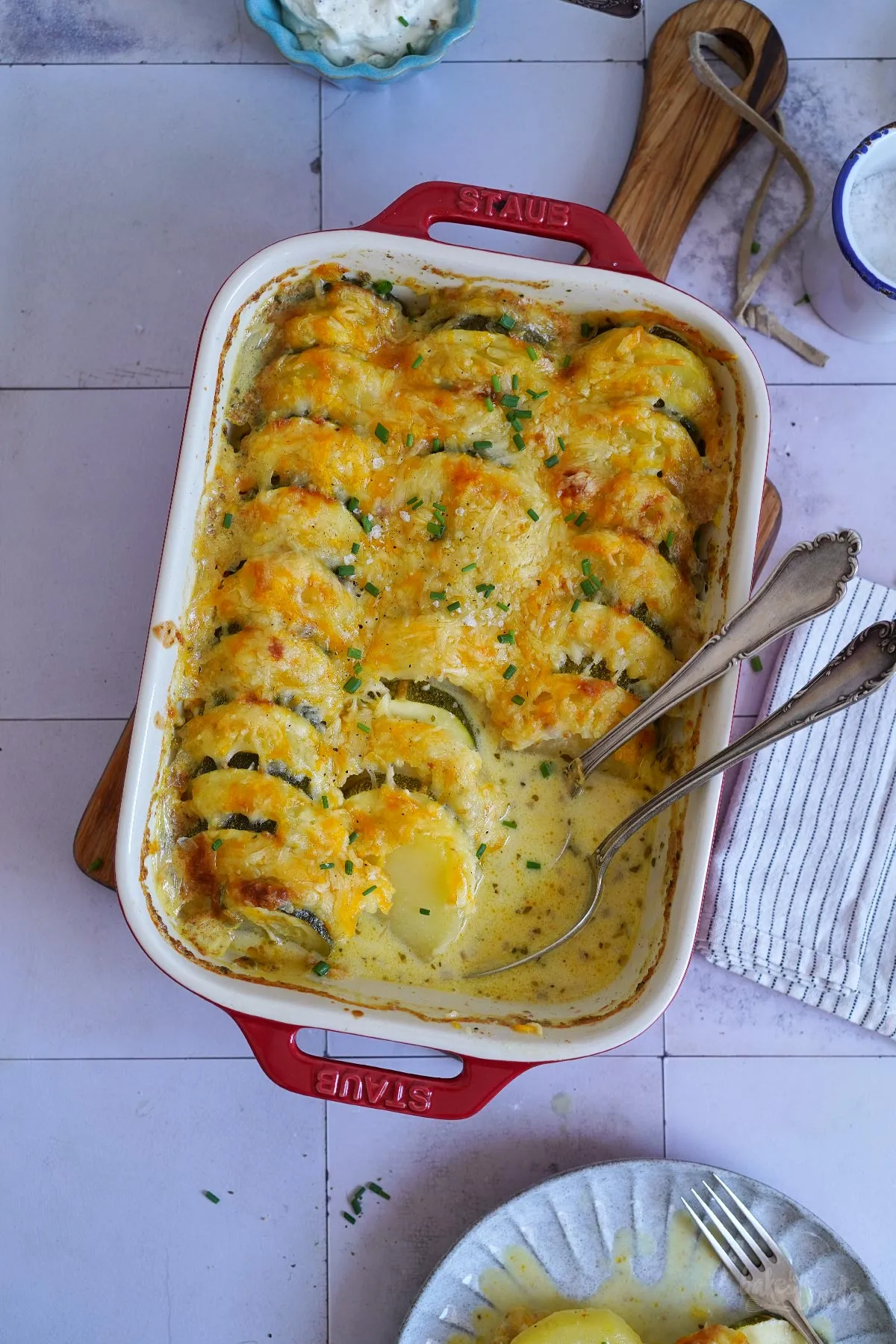 Schichtweise angeordnete Kartoffel- und Zucchinischeiben in einer Auflaufform