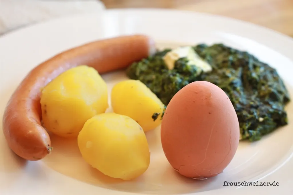 Schnelles Abendessen mit Kartoffeln, Ei, Spinat und Würstchen