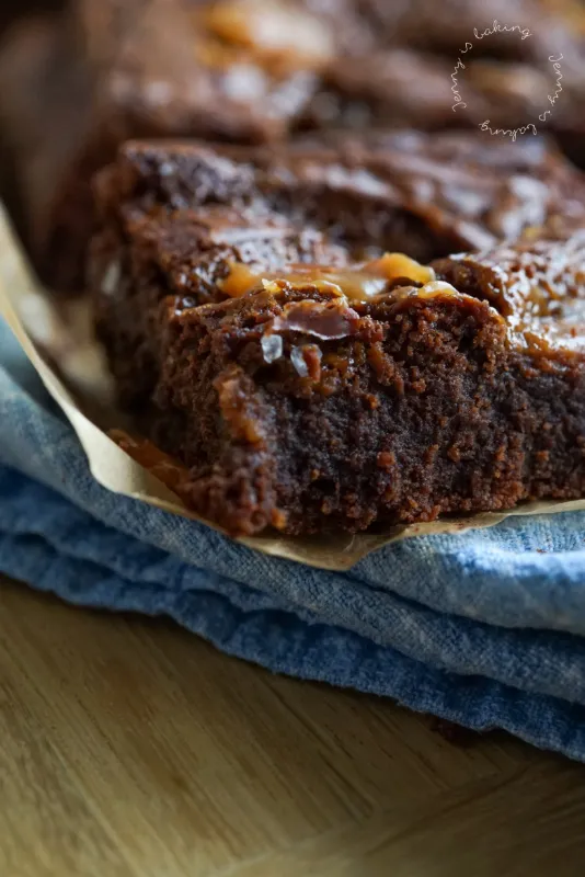 Schnitt eines fudgy Schoko Brownies, die Karamellschicht ist sichtbar