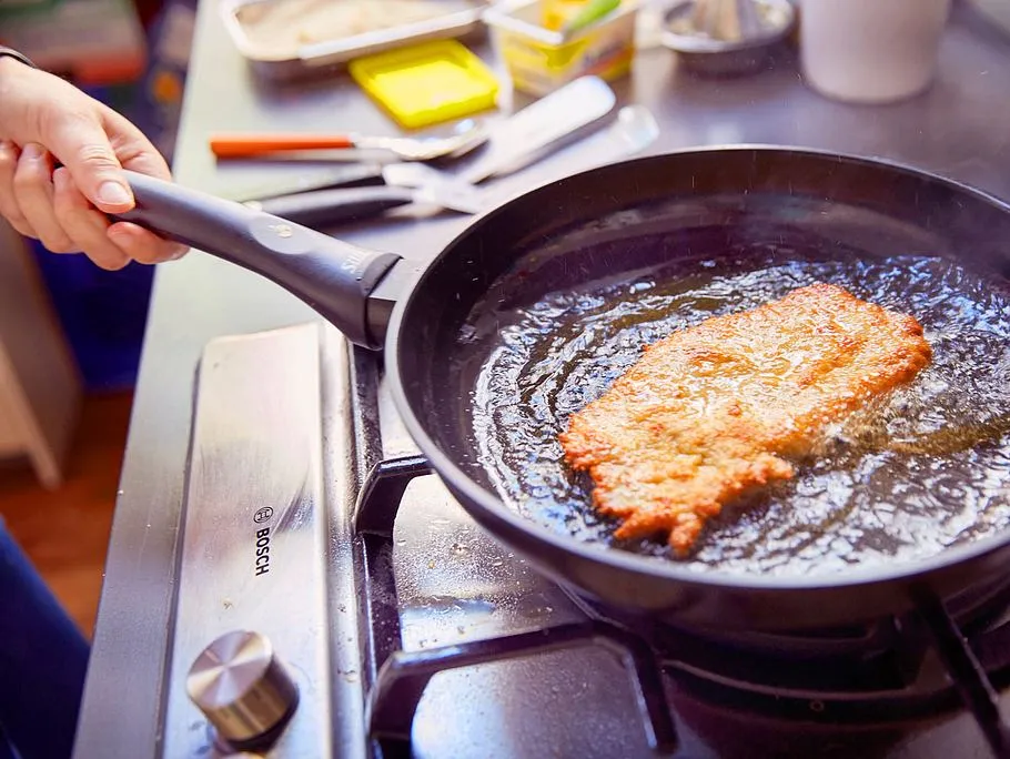 Schnitzel mit heißem Fett überziehen für extra Knusprigkeit
