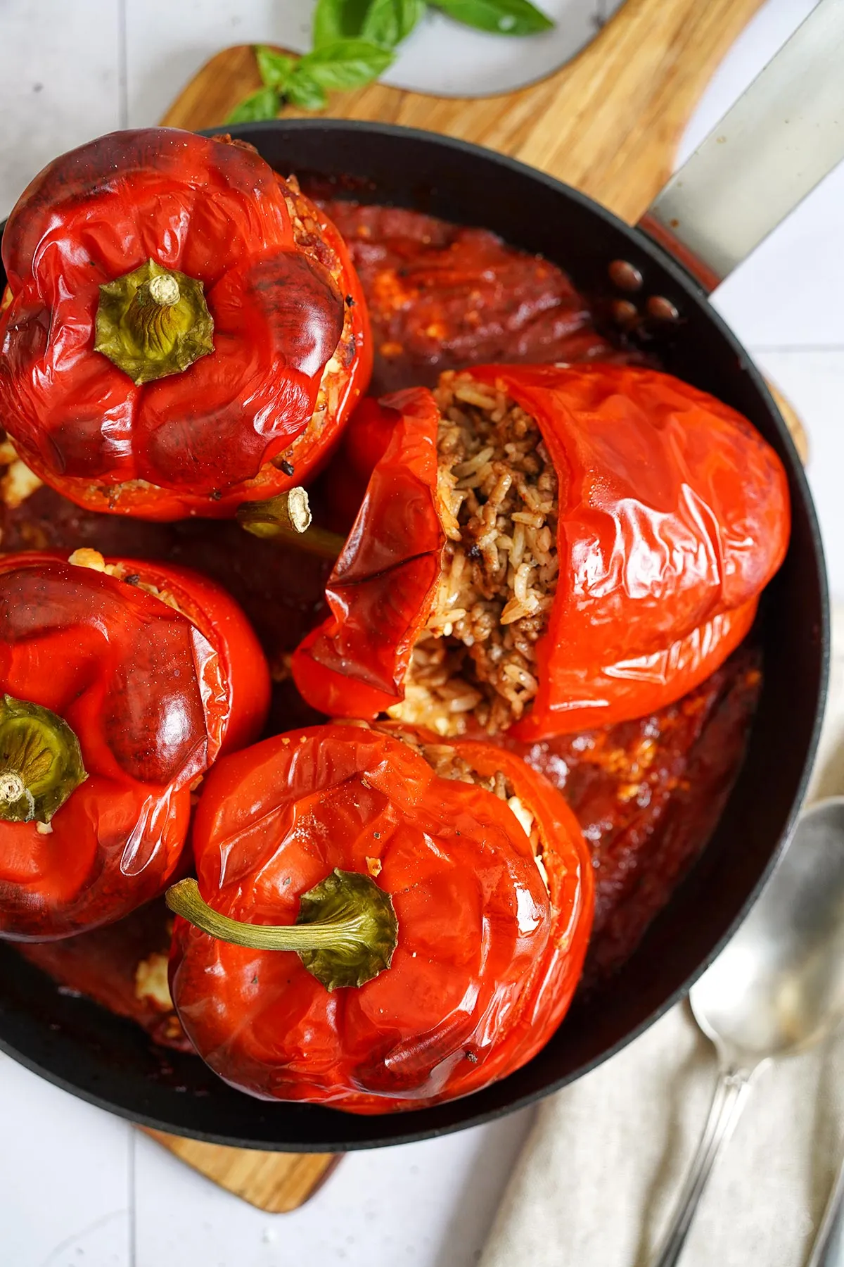 Schrägansicht von einer einzelnen gefüllten Paprika, die angeschnitten ist, um die Reis- und Fleischfüllung zu zeigen