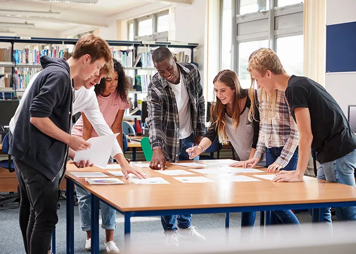 Schüler arbeiten in einer Gruppe an einem Planspiel.