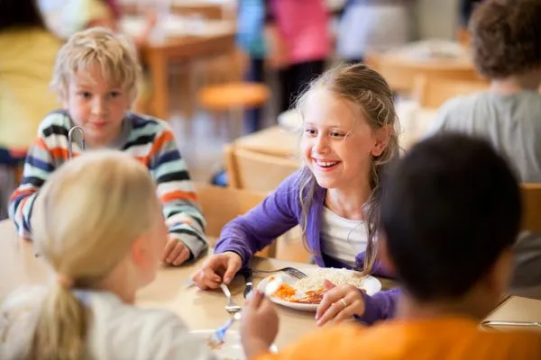 Schüler beim kostenlosen Mittagessen in der schwedischen Schulmensa, das Kind steht im Mittelpunkt