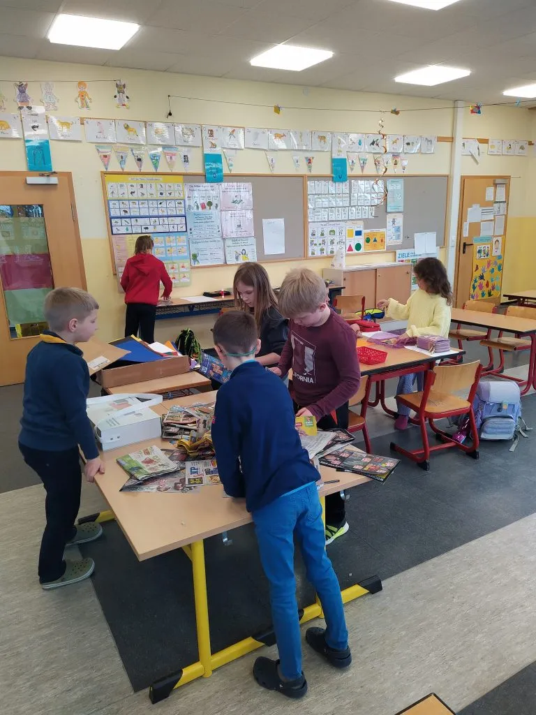 Schüler bereiten Informationsmaterial für eine Kleidersammelaktion im Dorf vor, um bedürftige Familien zu unterstützen.