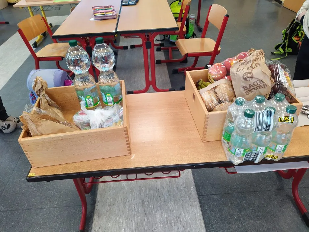 Schüler vergleichen ihre Einkäufe nach einem Experiment, das finanzielle Ungleichheit simuliert.