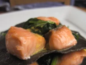 Schwarze Spinat-Lachs-Lasagne auf Tellern serviert