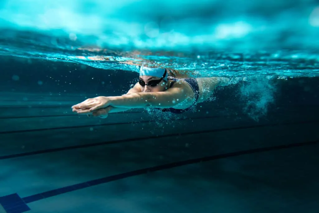 Schwimmerin im Wasser, trainiert Arm- und Rumpfkraft