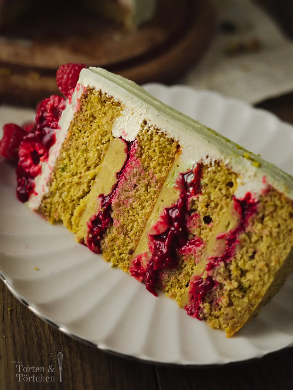 Seitenansicht der Pistazien Himbeer Torte mit Himbeeren
