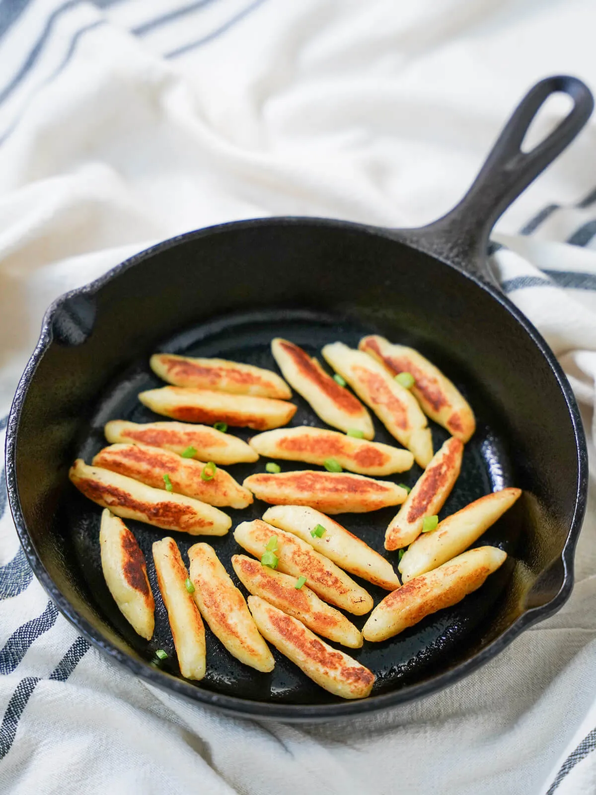 Seitenansicht einer Pfanne mit Schupfnudeln, deutschen Kartoffelnudeln/Klößchen.