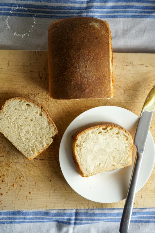 Selbstgebackenes Buttermilch-Toastbrot mit goldbrauner Kruste auf Holzbrett