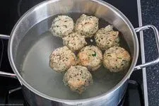 Semmelknödel ziehen sanft in siedendem Salzwasser, ein wichtiger Schritt für perfekte Knödel