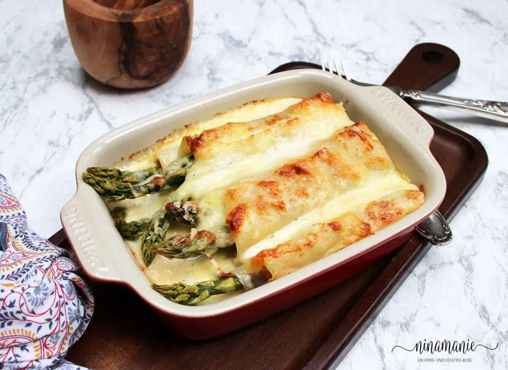 Servierfertige Spargel-Schinken-Lasagne-Röllchen frisch aus dem Ofen, leicht gebräunt und appetitlich angerichtet