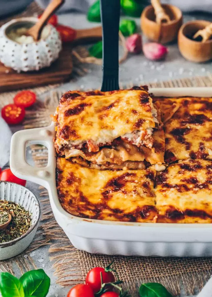 Servierte vegane Lasagne mit frischen Basilikumblättern in einer Backform, bereit zum Genuss.