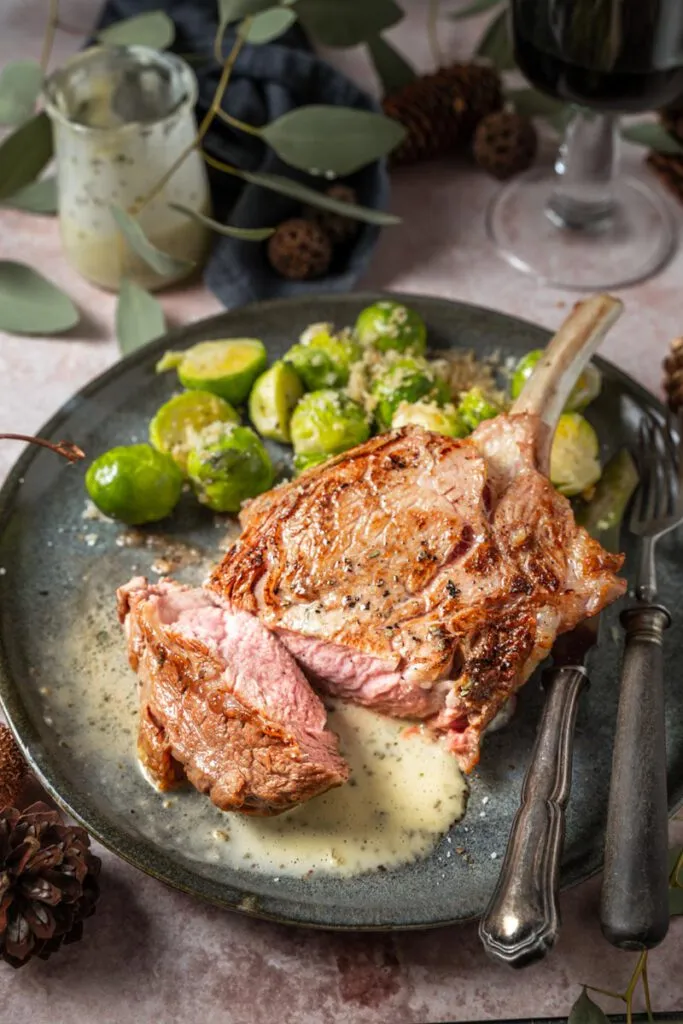 Serviertes Kalbs-Tomahawk-Steak mit Beilage