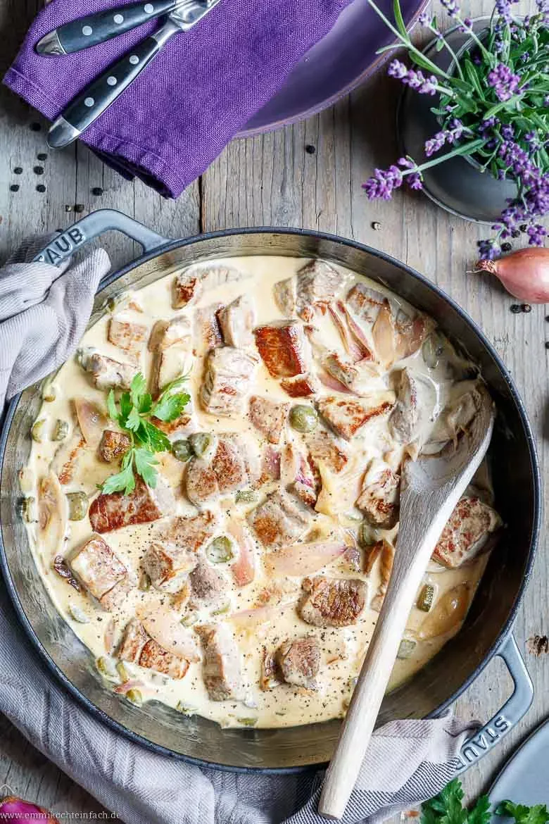 Serviertes Rahm-Rinderfilet Stroganoff mit frischem Brot und einem Glas Wein, ideal für besondere Rezepte mit Rinderfilet.