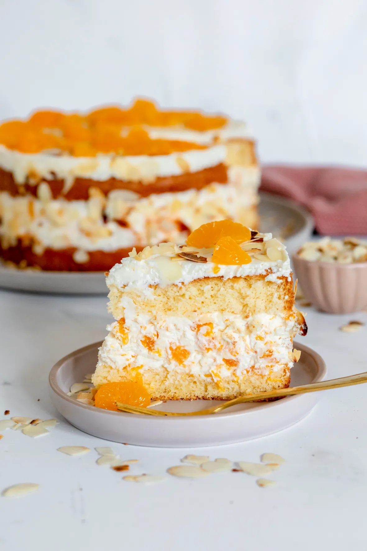 Sinnliche Nahaufnahme der Mandarinen-Sahne-Torte mit Mandeldeko