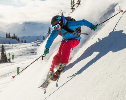Skifahrer gleitet auf frisch gefallenem Schnee die Piste hinab