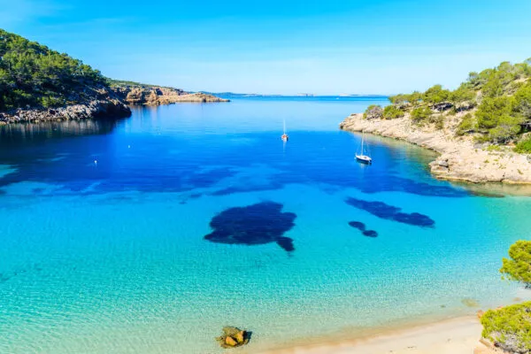 Sonnenverwöhnte Cala Salada auf Ibiza mit türkisblauem Wasser im Oktober – ideales Reiseziel für einen spätsommerlichen Badeurlaub
