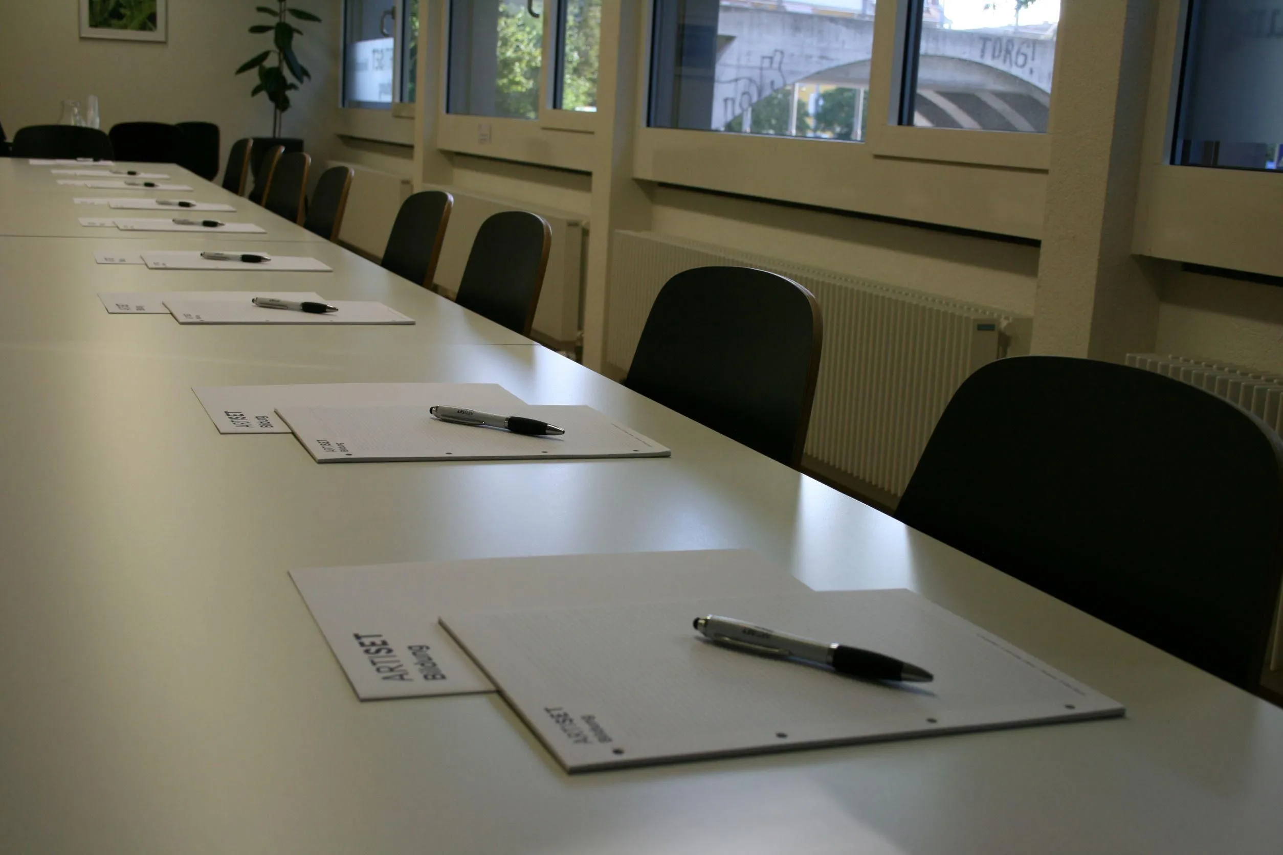 Sonniger Kursraum mit großen Fenstern und bequemen Stühlen bei ARTISET Bildung