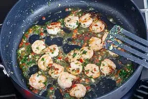 Soße aus Olivenöl zu den Garnelen geben und kurz anrösten.