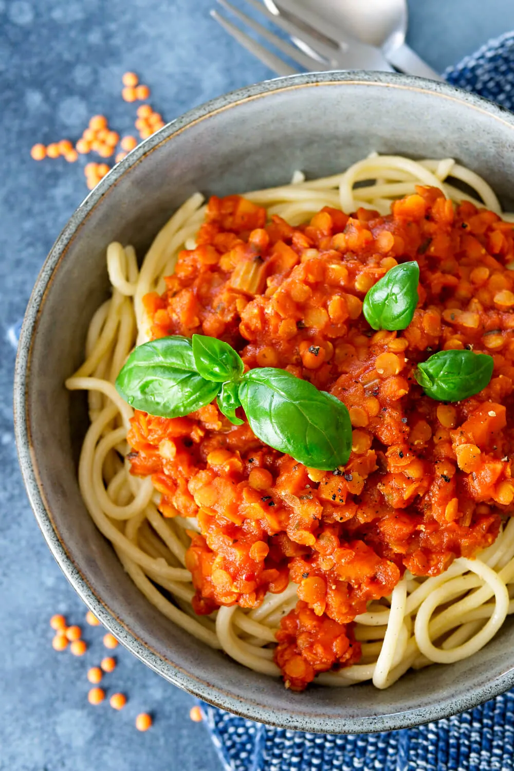 Spaghetti mit roter Linsenbolognese und frischem Basilikum in einer Schüssel