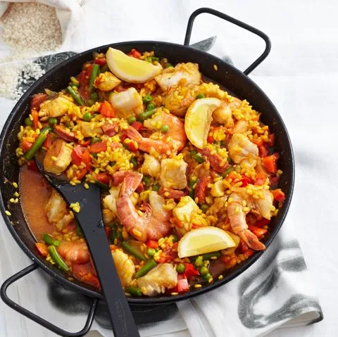 Spanische Paella mit Riesengarnelen, Hähnchenbrust, Chorizo, Erbsen, Tomaten und Bohnen.