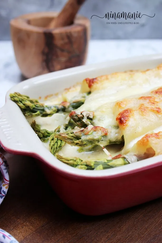 Spargel-Lasagne-Röllchen mit goldbrauner Béchamel und geschmolzenem Mozzarella in Nahaufnahme