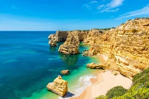 Spektakuläre Felsformationen und goldener Sandstrand an der Algarve, Portugal, ein sonnenverwöhntes Reiseziel im Juli.