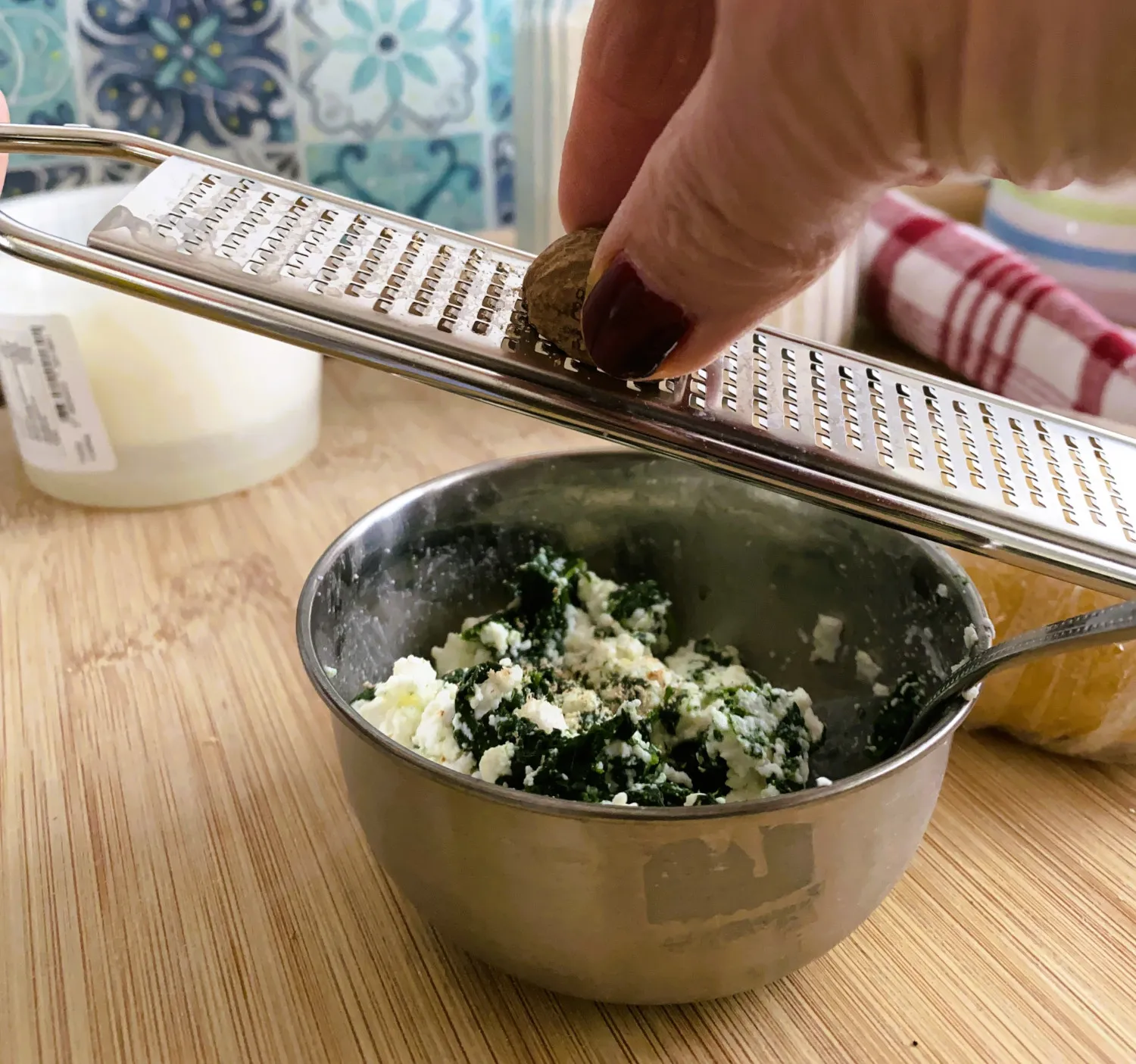 Spinat-Ricotta-Füllung wird sorgfältig auf ausgerollten Pastateig platziert, ein entscheidender Schritt beim Ravioli selber machen.