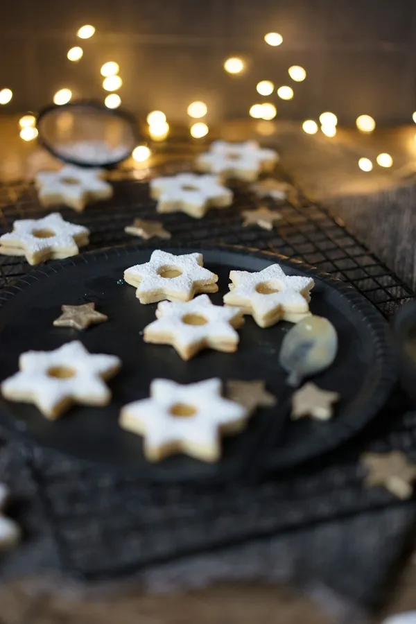 Spitzbuben mit gelber Lemon Curd Füllung und Puderzucker bestäubt